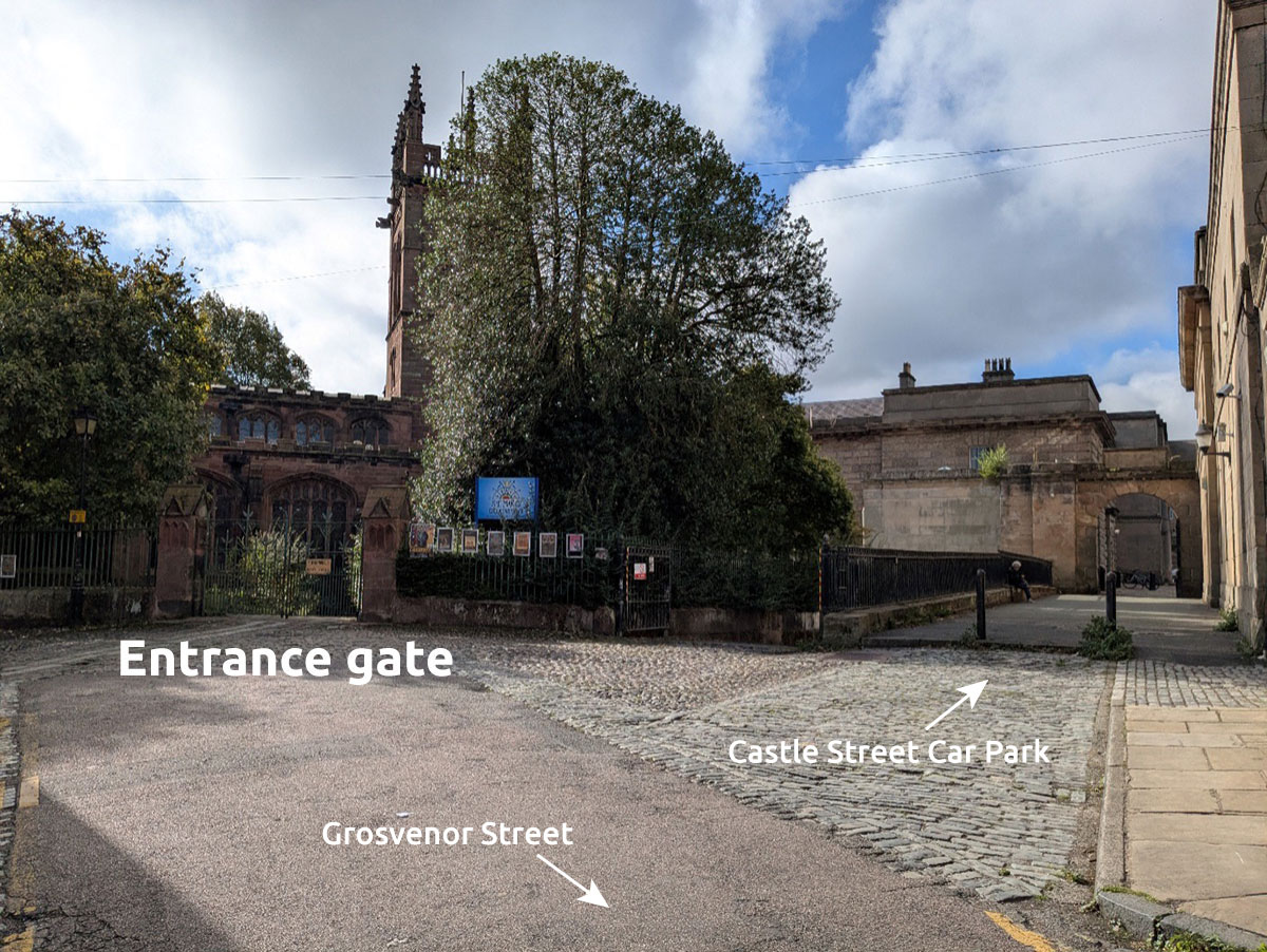 A photograph of the road leading to the St Mary’s entrance gate.  It shows a tarmacked road with cobbles in front of the gate and cobbles leading to the court delivery bay and walkway to the Castle Square car park.  The words ‘entrance gate’ have been placed on the photo to help orientate the viewer